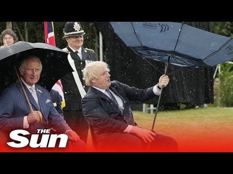 Boris Johnson struggles with umbrella at police memorial