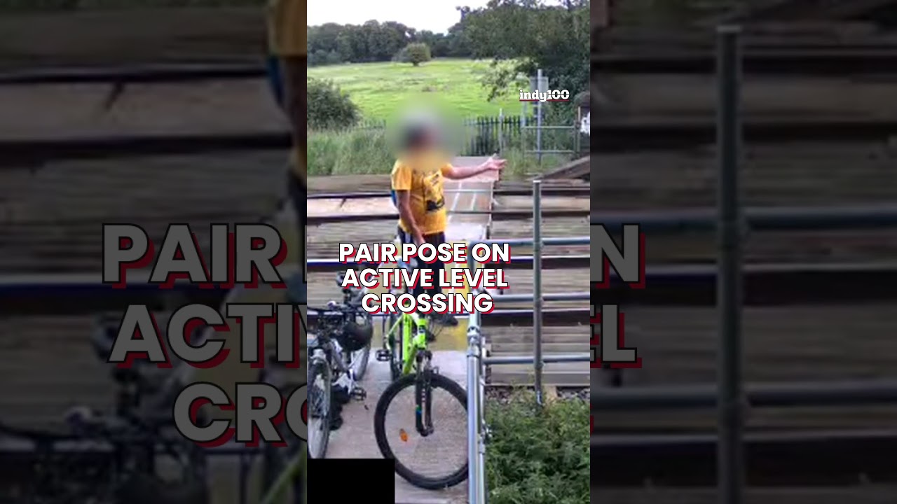 Shocking CCTV footage shows people posing on an active train crossing 