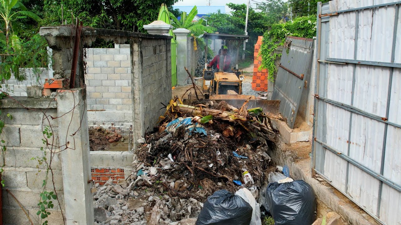 Bulldozer push the trash and fight the wall