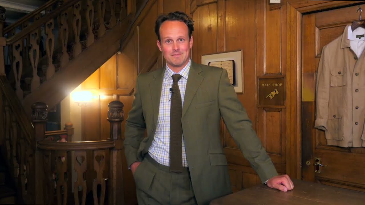 Male model wearing a dark green British tweed suit