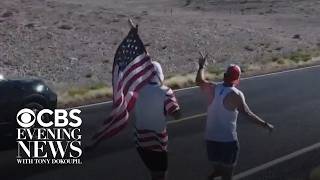 Group running American flag from coast to coast