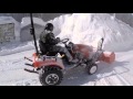 Минитрактор Kioti CS 2610 убирает снег фронтальным снегоуборщиком