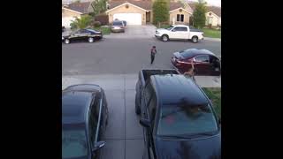 Kid throws ball at kid seated in bed of pickup truck then baby gets hit on head and falls out