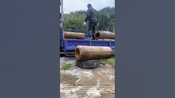 Unloading Metal Pipes from Truck: Manual Labor in Action