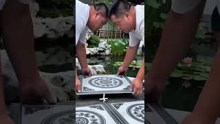 Hands align pattern—stone meets art with calm precision