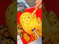 Someone peeling a fresh pineapple using a specialized spiral cutting tool at a vibrant street market