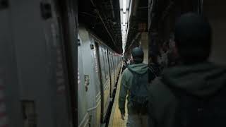 New York City subway station showing passengers waiting on platform for the train, glimpse into