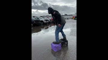 Man Ties Milk Crates to Shoes to Cross Flooded Parking Lot But Falls - 1403111