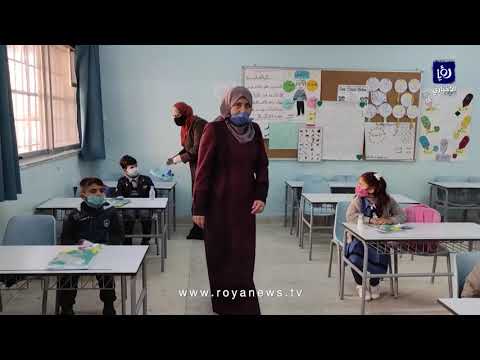 معلمة تشرح لطلبة الصف الأول الابتدائي التعليمات الصحية في يومهم الأول