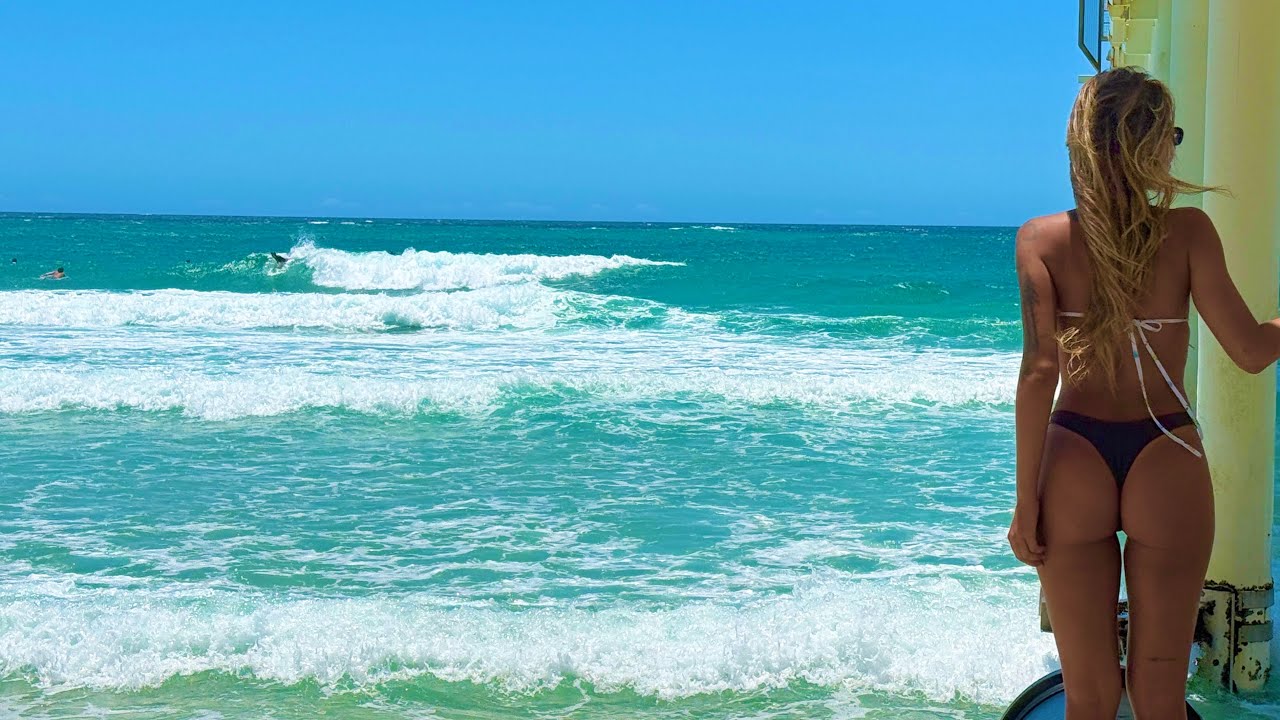 Серфинг на идеальных кристально чистых голубых волнах у пирса и пляжные красавицы