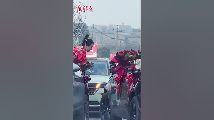 结婚接亲车队遇到其他接亲车队，新娘互相交换手捧花，彼此祝福。