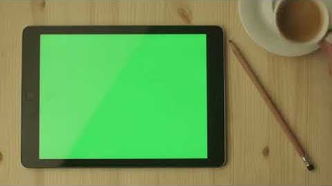 tablet with green screen laying on a wooden table in landscape mode vy90oyjl D