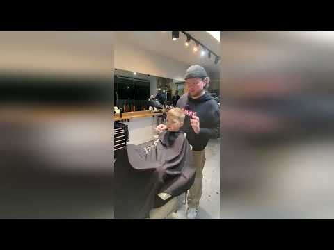 Heartwarming video shows barber with Tourette's cutting hair of young customer whilst swearing
