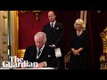 King Charles signals to aide to remove pens during signing of oath