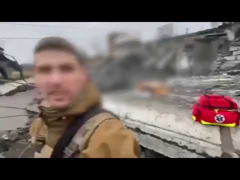 Ucraini in fuga da Irpin attraverso un ponte crollato sotto i bombardamenti.
