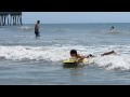 6 year old boy learning to boogie board in the ocean