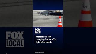 Motorcycle left dangling from traffic light after crash