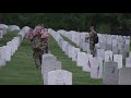 Military members place American flags on graves at Arlington National Cemetery