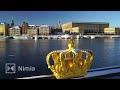 golden crown in foreground   Stockholm Royal Palace and old town in background