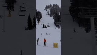 Skier jumps snow ramp near ski lift and lands on his head