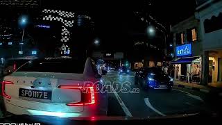 A car reversed towards the cam car at a junction after the traffic light turned green.