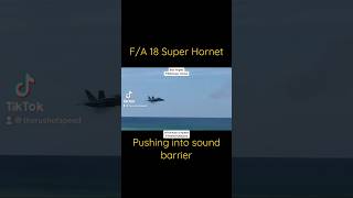 F/A 18 Superhornet high speed pass pushing into sound barrier.