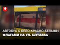 Автобус с бело-красно-белыми флагами ездит по улице Шугаева в Минске