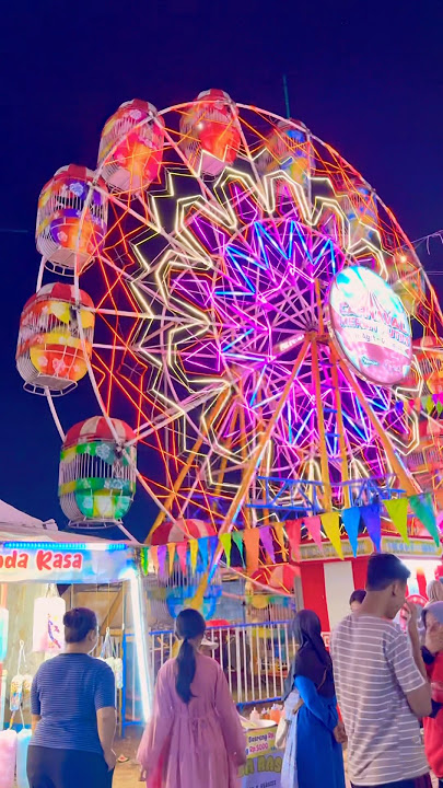 Giant purple and green Ferris wheel spinning around excitingly