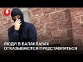 Женщина пытается говорить с людьми в балаклавах днем 6 сентября