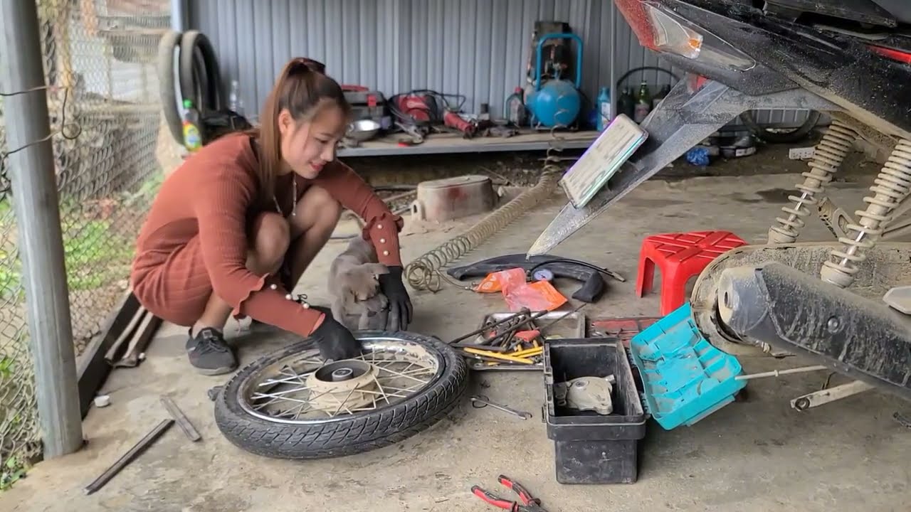 The repair girl changed the customer's broken tire and sold the old motorbike.