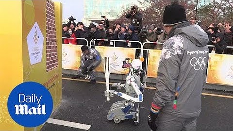 Robot cuts through wall to pass on Winter Olympic torch in S.Korea - Daily Mail