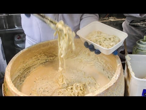 Hand Rolled Pasta Drowned in Melted Cheese Wheel. Street Food of Camden Lock market, London