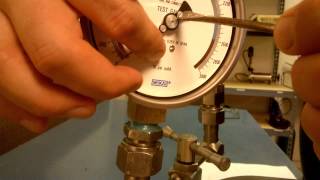 Calibration of a test gauge using a pressure gauge comparator.