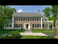 Traditional New England Colonial house with woodlands backdrop