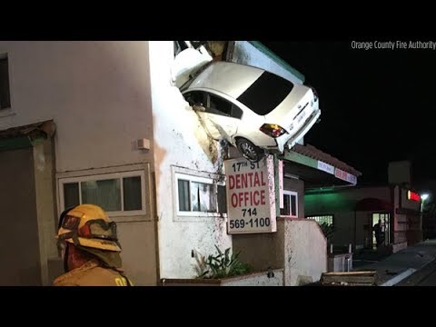 Car goes airborne, slams into second floor of building