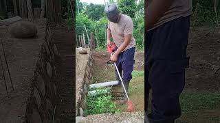 Motong rumput di kebun tanah berbatu