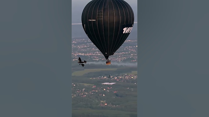 Daredevil gymnast performs gymnastics under hot-air balloon
