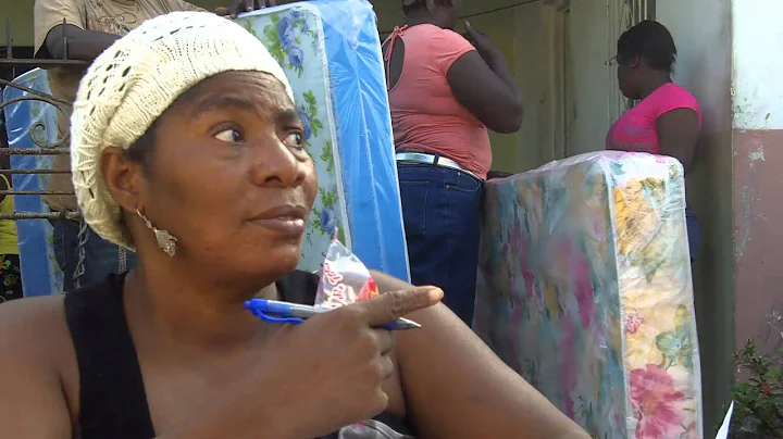 Jamaican resident Yvonne Cox distributes mattresse...