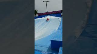 Boy rides boogie board on flow rider and crashes into wall