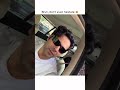 Varun sporting a pair of bold, thick-frame black rectangular sunglasses while seated inside a car.