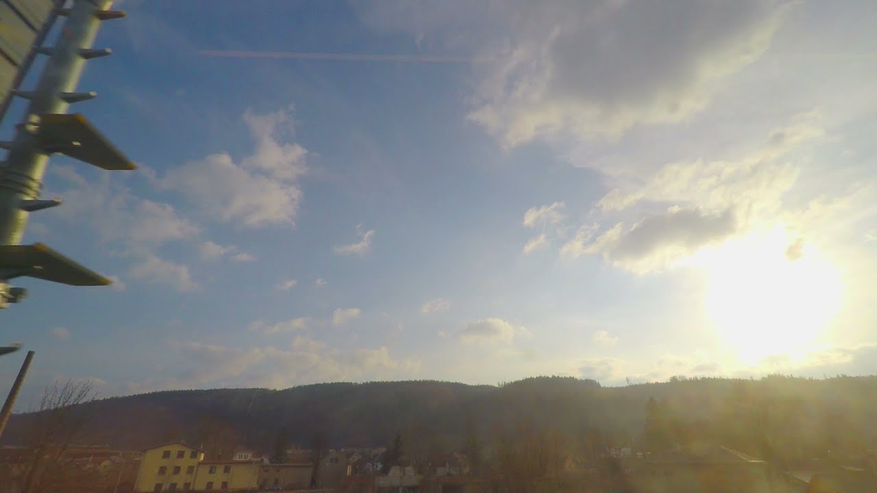 View through train window, sunny blue sky with clouds, trees, hills on horizon. Stock Footage
