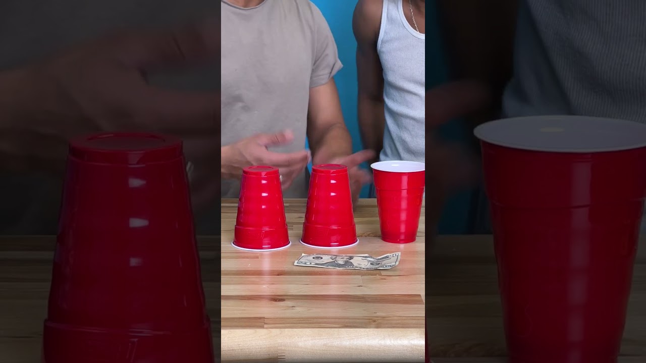 men plays together with red plastic cup 