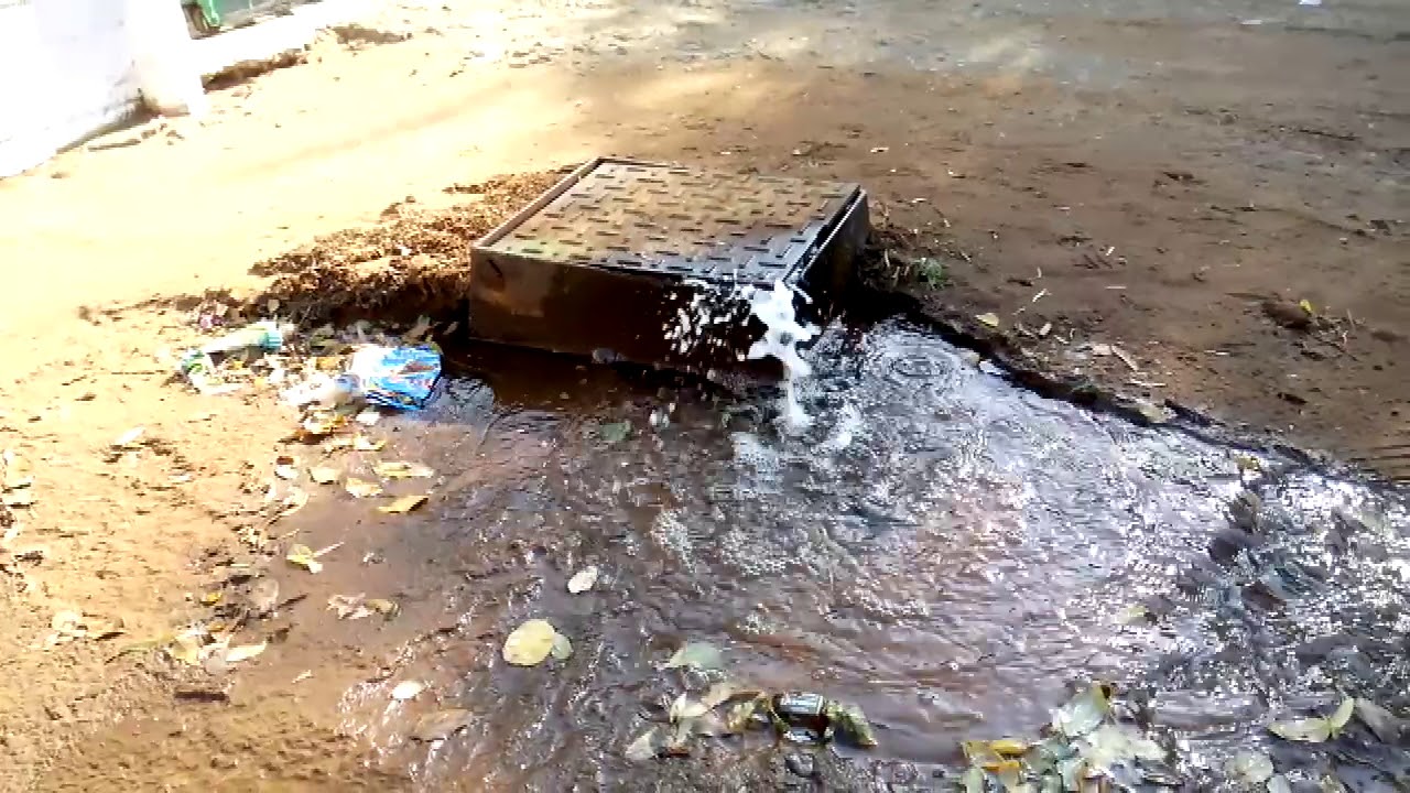 Rioolwater stroom by selfgemaakte kanaal op erf uit