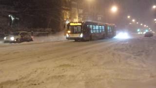 Articulated STM bus moving through the snow near Guy/Sainte-Catherine in Montreal