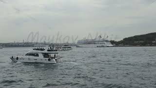 D-Log M. Istanbul, Turkey. Large two-deck passenger vessel passing Bosphorus with docked cruise s...