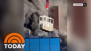 Watch: Crane operator rescues worker from burning high-rise
