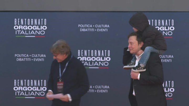 Elon Musk arriving at PM Meloni's party political rally with his young son | AFP