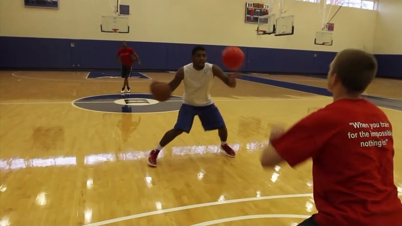 Kyrie Irving doing a ball handling drill with his trainer