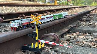 Assembling a long CC206 toy train on real rails, it then derailed and hit an automatic barrier.