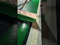 Spreading green resin coating on a bicycle path with a large squeegee for surface finishing